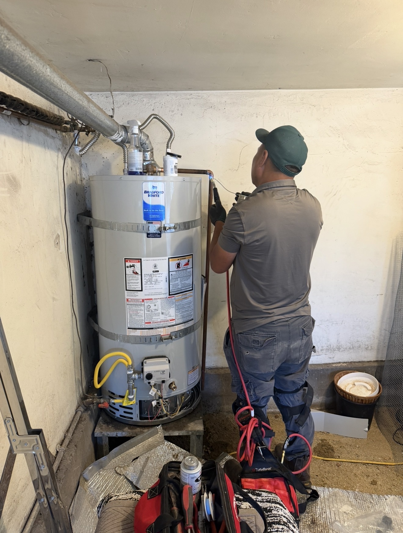 Green Eagle plumber installing a Bradford White water heater